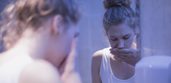 患有饮食失调的年轻女孩在生病后捂住了嘴