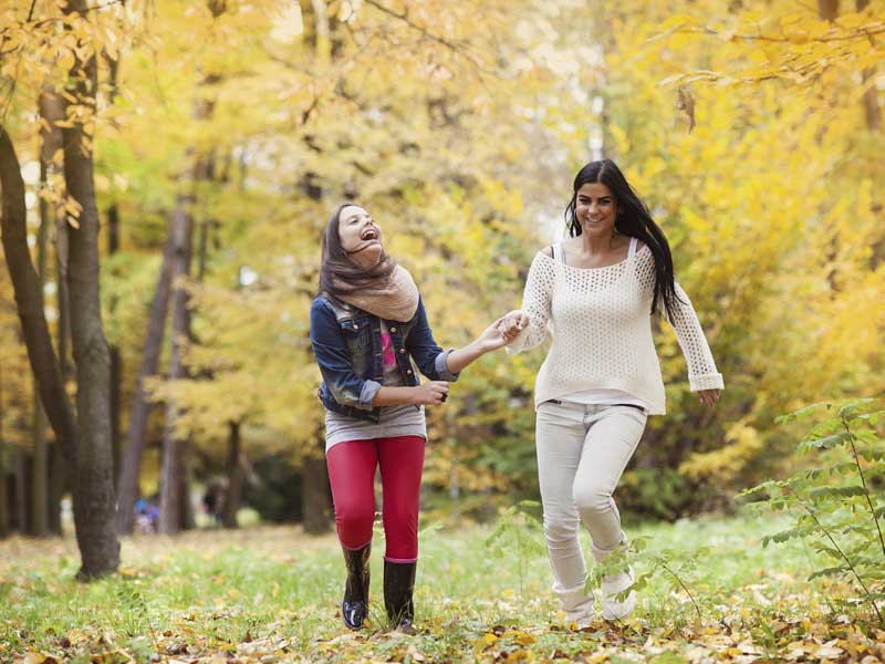 母亲和女儿在秋天的大自然中玩耍